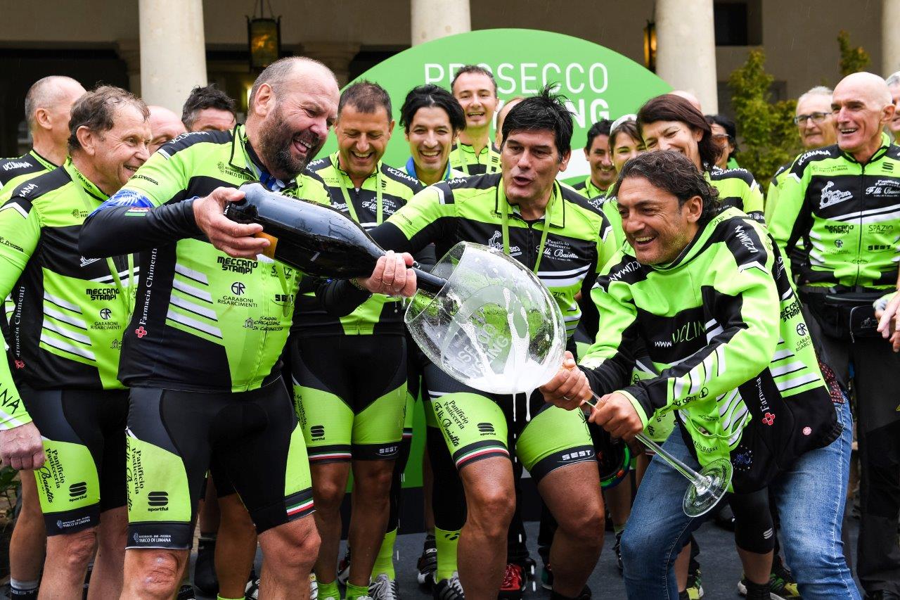 Prosecco Cycling_Chiappucci con il bicchiere in mano sul palco delle premiazioni