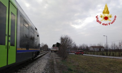 Il treno sta arrivando, ma tra le sbarre del passaggio a livello c'è un camion fermo