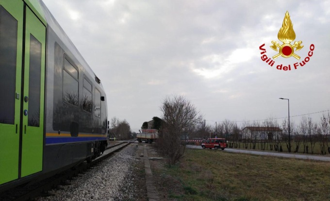 Il treno sta arrivando, ma tra le sbarre del passaggio a livello c’è un camion fermo