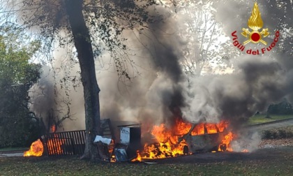 Le quattro vecchie auto parcheggiate sotto l'albero prendono fuoco